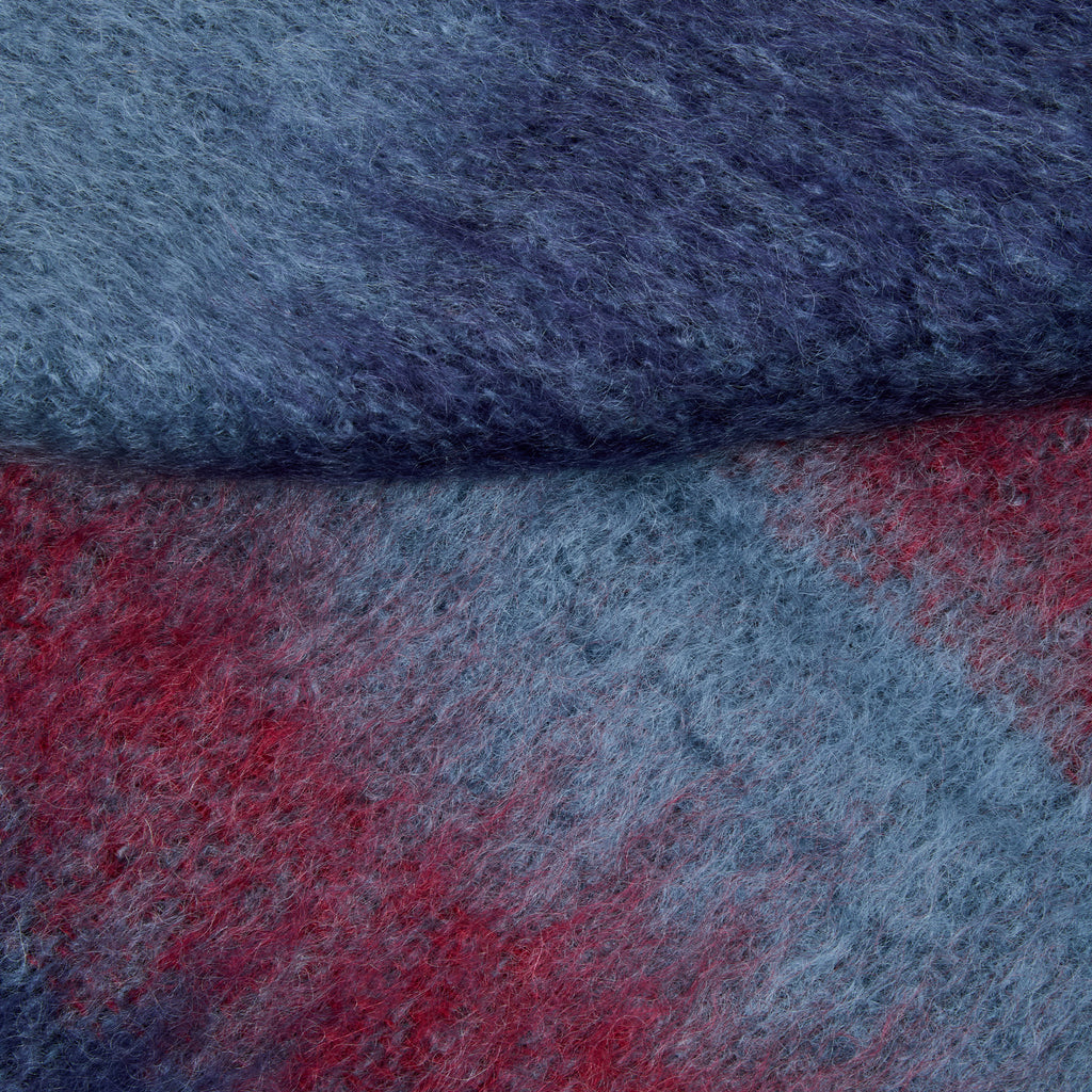 Close-up of a textured wool fabric in a heathered blue-gray tone with a red section visible along the bottom and right side.